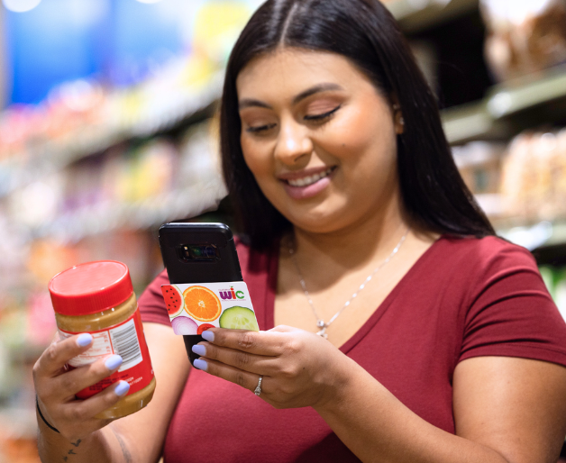 Woman holding a phone and WIC card